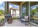 Relaxing covered patio with chairs, table, and a view of the backyard and lake at 3443 Sagebrush St, Harmony, FL 34773