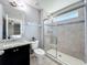 Clean bathroom featuring a shower with glass door and vanity with dark cabinets at 3450 Puxton Dr, Orlando, FL 32824