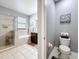 Bathroom featuring a toilet, vanity, shower, and soaking tub with tiled flooring at 3450 Puxton Dr, Orlando, FL 32824