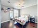 Charming bedroom with floral bedding, hardwood floors, and a ceiling fan at 3450 Puxton Dr, Orlando, FL 32824