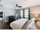 Comfortable bedroom with a leaf-design ceiling fan, dark wood floors, and decorative curtains at 3450 Puxton Dr, Orlando, FL 32824