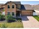 Charming two-story home with well-manicured lawn, brick driveway, and an attached two-car garage at 3450 Puxton Dr, Orlando, FL 32824