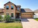 Charming two-story home with well-manicured lawn, brick driveway, and an attached two-car garage at 3450 Puxton Dr, Orlando, FL 32824