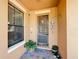 Inviting front door with unique hardware, potted plants, and decorative accents creating a welcoming entrance at 3450 Puxton Dr, Orlando, FL 32824