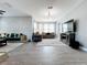 Spacious living room with elegant chandelier, neutral color palette, stylish decor, and wood-look tile flooring at 3450 Puxton Dr, Orlando, FL 32824