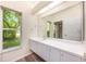 Bathroom with modern vanity, large mirror and a window with natural light at 3831 River Hollow Ct, Oviedo, FL 32765