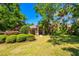 Inviting home showcasing lush landscaping with manicured bushes, mature trees, and a well-maintained lawn at 3831 River Hollow Ct, Oviedo, FL 32765