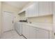 Bright laundry room with modern washer, dryer, utility sink, and ample cabinet space at 3831 River Hollow Ct, Oviedo, FL 32765