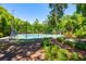 A well-maintained tennis court surrounded by lush trees, with a green and blue surface at 3831 River Hollow Ct, Oviedo, FL 32765