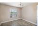 Sunlit bedroom features neutral colors, wood-look floors, fan and a window with blinds at 3960 Southpointe Dr # 501, Orlando, FL 32822