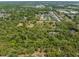 Aerial shot showcases a parcel with mature trees, residential area, and pond at 4000 Rouse Rd, Orlando, FL 32817