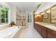 Large bathroom features a glass shower, jacuzzi tub, and double vanity with green accent wall at 4000 Rouse Rd, Orlando, FL 32817