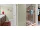 Well-lit bathroom with wood cabinets, double sinks, decorative rug, and tiled glass shower at 4000 Rouse Rd, Orlando, FL 32817
