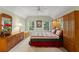 Cozy bedroom featuring a dresser, bedside table, and windows overlooking lush greenery at 4000 Rouse Rd, Orlando, FL 32817