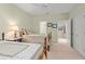 Bright bedroom with twin beds, plush carpet, and a door to another room at 4000 Rouse Rd, Orlando, FL 32817