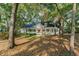 Beautiful white home with a large porch and green shutters, surrounded by trees at 4000 Rouse Rd, Orlando, FL 32817