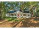 Charming home featuring a red front door and a welcoming porch with white columns, nestled among mature trees at 4000 Rouse Rd, Orlando, FL 32817