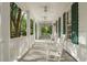 Inviting front porch featuring white rocking chairs and a beadboard ceiling with fans, perfect for relaxation at 4000 Rouse Rd, Orlando, FL 32817