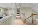 Upstairs hallway featuring decorative columns, staircase, and light walls and carpet at 4000 Rouse Rd, Orlando, FL 32817