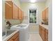 Functional laundry room with cabinets, a sink, washer and a window offering natural light at 4000 Rouse Rd, Orlando, FL 32817