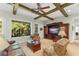 Comfortable living room with exposed beams, large windows, and an entertainment center, perfect for relaxing at 4000 Rouse Rd, Orlando, FL 32817
