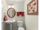 Charming powder room featuring a pedestal sink, oval mirror and decorative wall art at 4000 Rouse Rd, Orlando, FL 32817