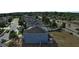 Aerial view of a blue home with solar panels in a suburban neighborhood on a sunny day with a road to the right at 4058 Brookshire Cir, Eustis, FL 32736