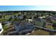 Aerial view of a blue home with solar panels, a pond, and other homes in a suburban neighborhood on a sunny day at 4058 Brookshire Cir, Eustis, FL 32736