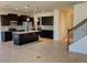 Open-concept kitchen with dark cabinets, stainless appliances, granite counters and a large island near stairs at 4058 Brookshire Cir, Eustis, FL 32736