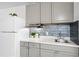 A stylish kitchen features updated gray cabinets, a modern backsplash, and stainless-steel appliances, offering a sleek design at 43420 Highway 27 # 121, Davenport, FL 33837