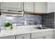 Kitchen featuring gray cabinets, marbled countertops, and a gray subway tile backsplash at 43420 Highway 27 # 121, Davenport, FL 33837