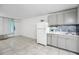 Efficient kitchen area with grey cabinets, gray backsplash and white refrigerator at 43420 Highway 27 # 121, Davenport, FL 33837