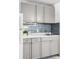 Kitchen with modern grey cabinets, gray backsplash, and marble countertop at 43420 Highway 27 # 121, Davenport, FL 33837