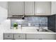 A stylish kitchen features updated gray cabinets, a modern backsplash, and stainless-steel appliances, offering a sleek design at 43420 Highway 27 # 121, Davenport, FL 33837