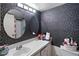 Inviting bathroom featuring a modern vanity with sink, round mirrors, and stylish wallpaper at 440 Orienta Point St, Altamonte Springs, FL 32701