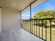Balcony with tiled floor and black metal railing overlooking a green lawn and mature tree at 4403 Hector Ct # 3, Orlando, FL 32822