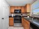 Charming kitchen features wooden cabinets, black appliances, and tiled floors at 4403 Hector Ct # 3, Orlando, FL 32822