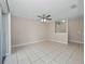 Open living room with neutral walls, tiled floors, ceiling fan, and view of entry at 4403 Hector Ct # 3, Orlando, FL 32822