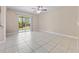 Bright living room with tile floors and sliding glass doors leading to a balcony overlooking greenery at 4403 Hector Ct # 3, Orlando, FL 32822