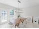 Contemporary dining room with a rectangular wood table, white chairs, stylish lighting, and shuttered windows at 478 Water St, Kissimmee, FL 34747