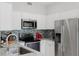 Contemporary kitchen showcasing stainless steel appliances, modern backsplash, and white cabinetry at 478 Water St, Kissimmee, FL 34747