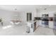 Open-concept kitchen and dining area with modern appliances, marble countertops, and stylish dining set at 478 Water St, Kissimmee, FL 34747