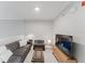 Bright living room with gray sofa, soft furnishings, a flat-screen TV, and a decorative lighting arrangement at 478 Water St, Kissimmee, FL 34747