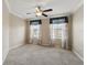 Neutral bedroom with two windows allowing ample light in, ceiling fan, carpeted floors, and decorative curtains at 5341 Via Appia Way, Sanford, FL 32771