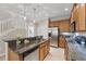 Well-lit kitchen featuring stainless steel appliances, wood cabinets, granite counters, and light-wood flooring at 5341 Via Appia Way, Sanford, FL 32771