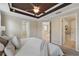 Spacious main bedroom with decorative ceiling, neutral walls, plush carpet, and view to the main bathroom at 5341 Via Appia Way, Sanford, FL 32771