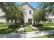 Inviting townhouse exterior with symmetrical design, lush landscaping, and charming entryway at 5838 Cypress Hill Rd, Winter Garden, FL 34787