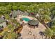 An aerial view of a community pool area with a gazebo and lounge seating surrounded by palm trees at 6178 Westgate Dr # 101, Orlando, FL 32835