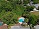 Aerial view of a lush backyard with a sparkling swimming pool surrounded by mature trees and privacy at 623 Green Meadow Ave, Maitland, FL 32751