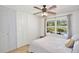 Cozy bedroom features a ceiling fan, closet, window, and a pool view at 623 Green Meadow Ave, Maitland, FL 32751